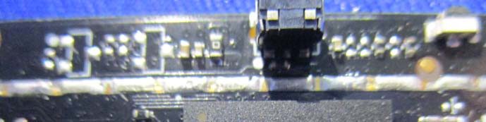 Close-up of large IC with FPC connector and dense passives.