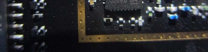 PCB close-up with RF shield ground ring and central IC.