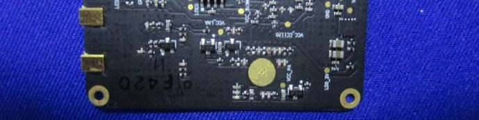 PCB detail with passives, edge pads, and high-density layout.