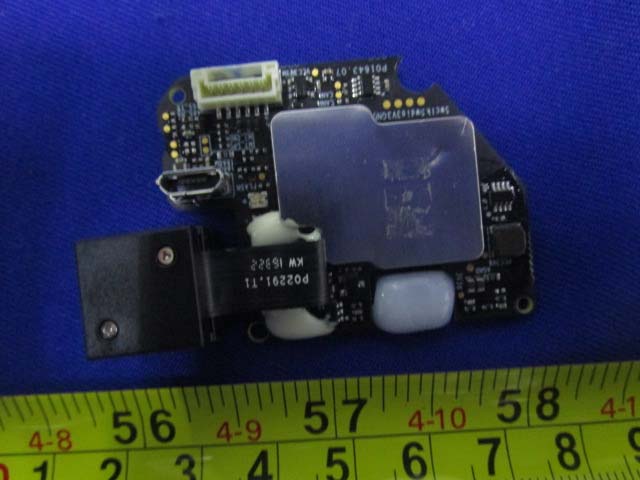 Dense PCB with RF shield, connectors, and power regulation.
