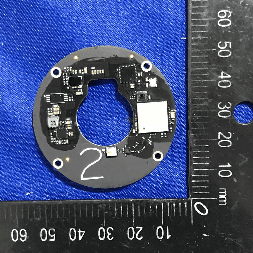 Circular PCB with shielded RF section and high-density components.