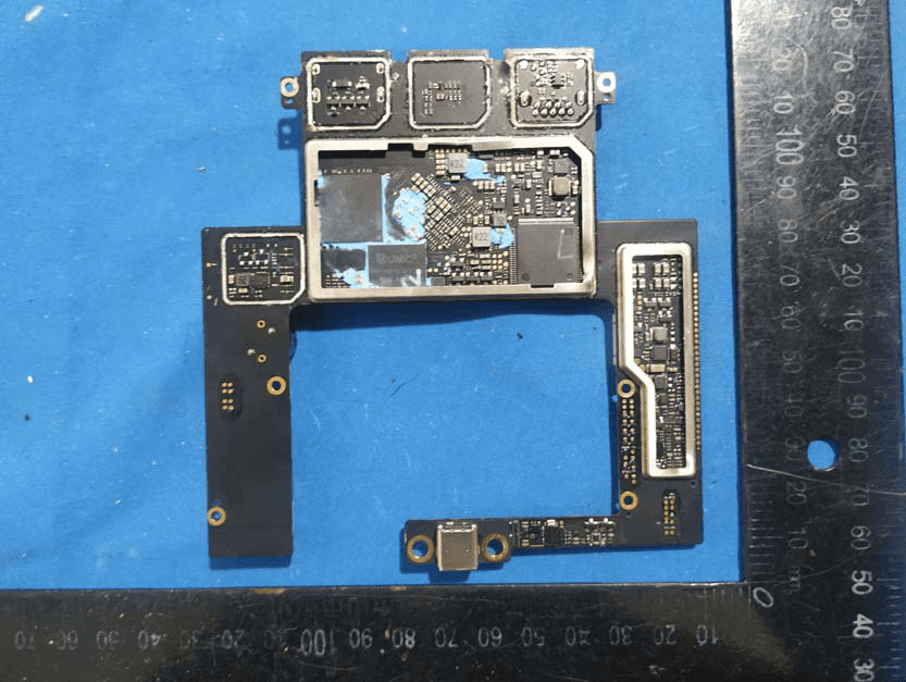 Main processing board with BGA SoC, memory, and RF connectors under EMI shields.