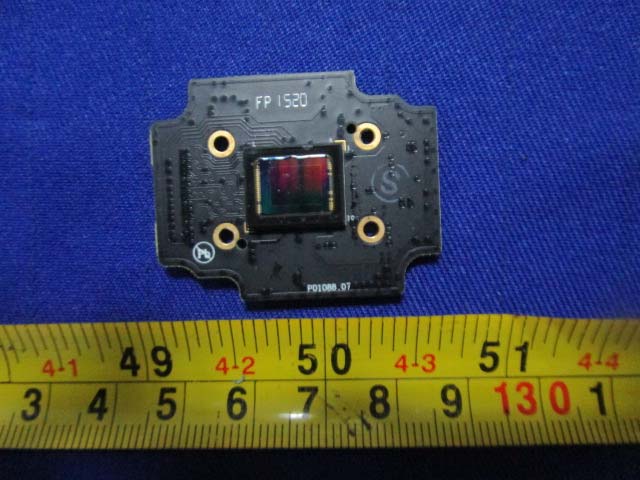 Camera sensor board with exposed CMOS image sensor and gold mounting points.