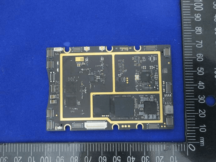 Black multilayer PCB with large ICs, connector array, and EMI shield regions.