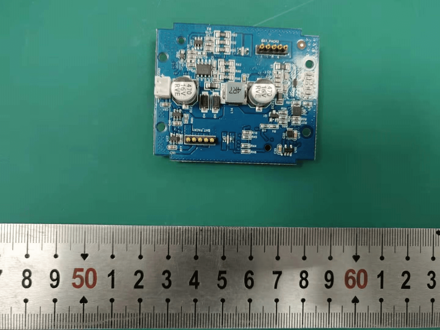 Power management PCB with large capacitors and inductor for efficient voltage regulation.