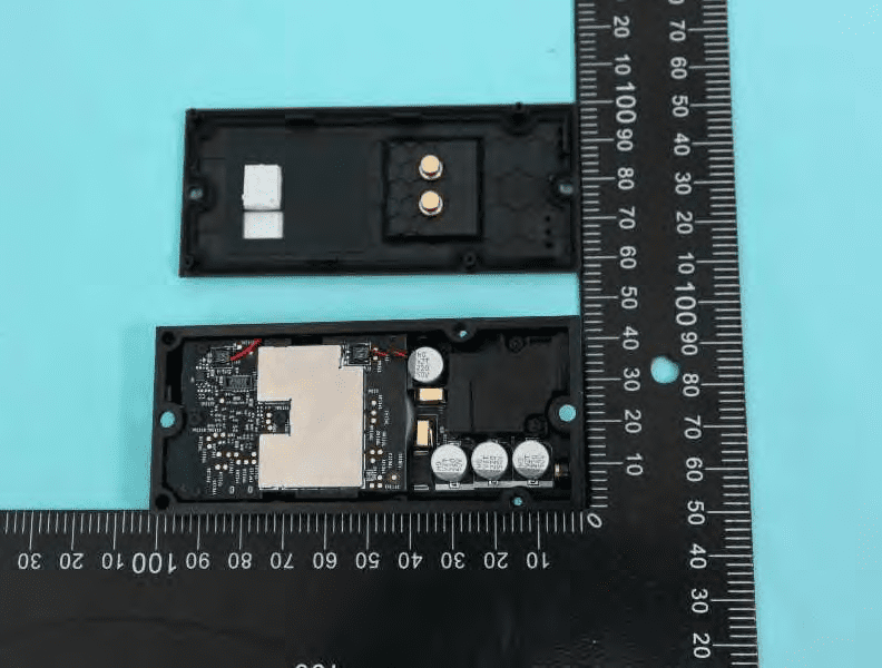 Dense PCB with shielded SoC, large capacitors, and test pogo pins.